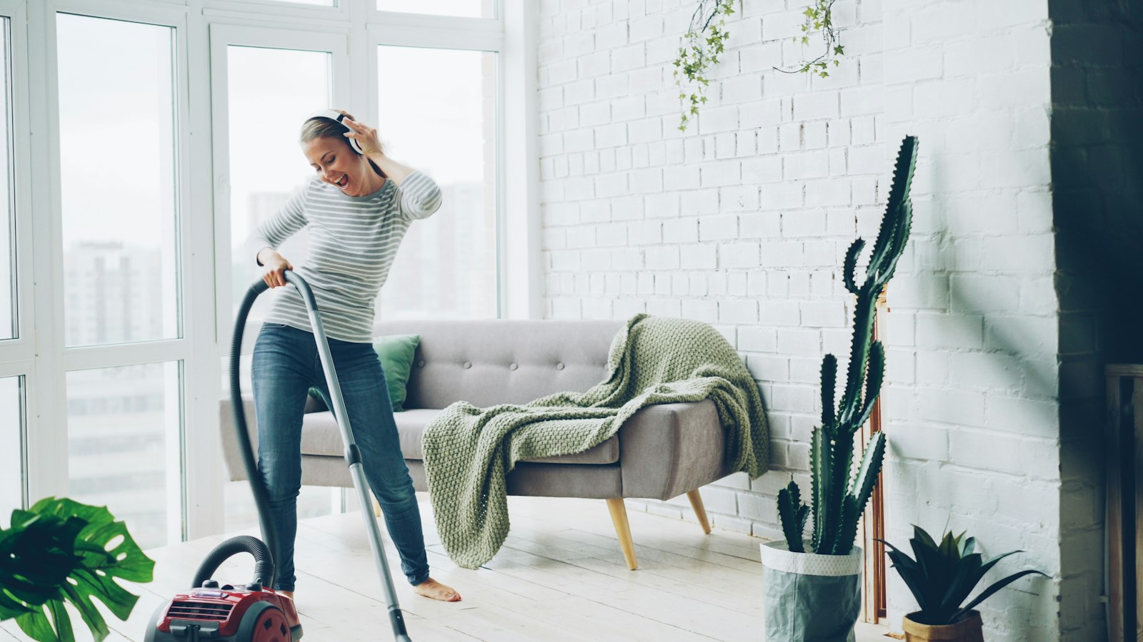 Professional house cleaner vacuuming a bright living room in a Dayton, Ohio home