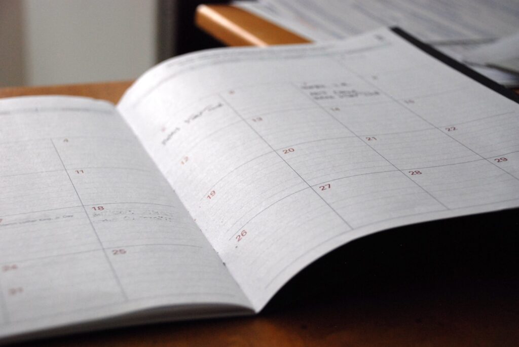 Open monthly planner on a desk used to plan a weekly, bi-weekly, or monthly house cleaning schedule